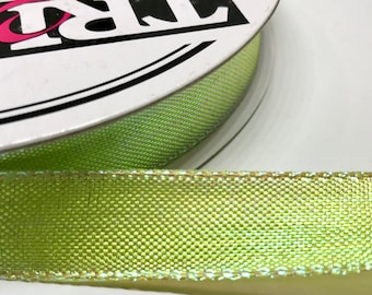 May include: A spool of lime green iridescent ribbon with a gold edge. The ribbon is on a white spool with the word "RIBBON" printed on it.