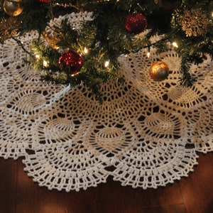 May include: White crocheted Christmas tree skirt with a delicate lace pattern.