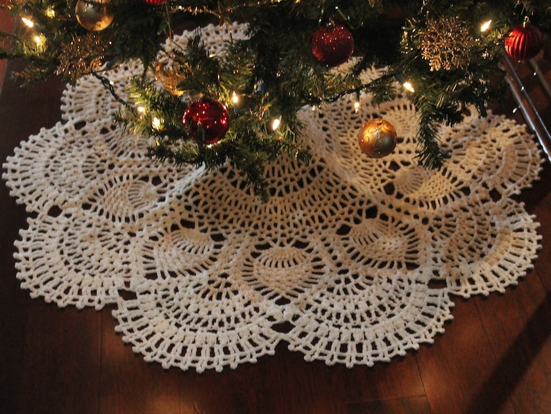 May include: White crocheted Christmas tree skirt with a delicate lace pattern.