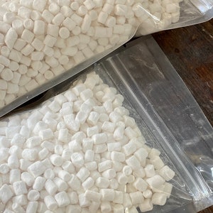 Puede incluir: Una bolsa de plástico transparente llena de pequeños malvaviscos blancos.