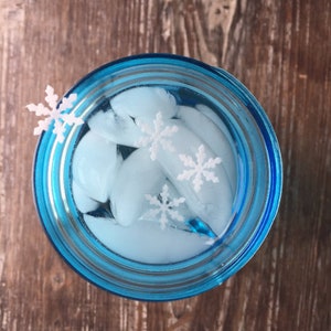 May include: A blue glass jar filled with ice cubes and white snowflake decorations.