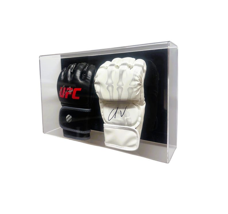 May include: A clear acrylic display case with two pairs of boxing gloves. One pair is black with red UFC lettering and the other pair is white with a skeleton design. The white gloves are signed "DV".