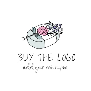 May include: A hand-drawn logo design featuring a light blue oval with a white stripe and a pink rose with green leaves. Purple flowers and green stems are on top of the oval. The text "BUY THE LOGO add your own name" is below the oval.
