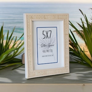May include: White 5x7 inch picture frame with a woven rattan design. The frame is matted to fit a 4x6 inch photo. The text "5x7 Rattan Frame 4x6 Matted www.shoretupshop.com" is printed on the mat.