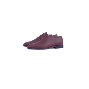 Peut inclure: Une paire de chaussures en cuir marron &agrave; lacets avec un talon bas.