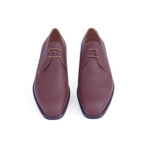 Peut inclure: Une paire de chaussures en cuir marron &agrave; lacets avec une pointe carr&eacute;e.