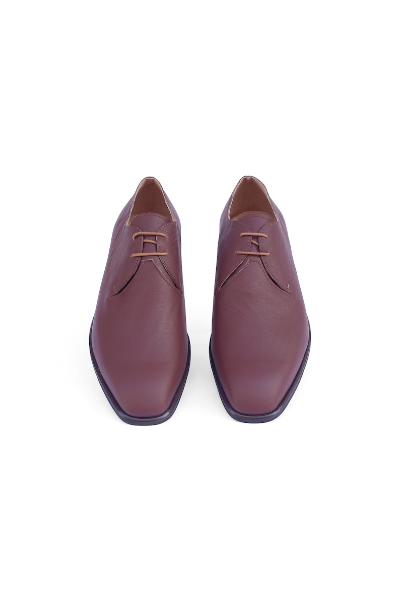 Peut inclure: Une paire de chaussures en cuir marron &agrave; lacets avec une pointe carr&eacute;e.