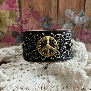 Gold PeAcE Sign Concho Brazalete de cuero negro&gt; Brazalete de cuero de la paz. Pulsera de cuero. Joyería del signo de la paz. Joyas hippies. retro