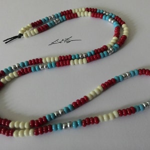 May include: A multi-strand necklace made of cream, red and blue beads with silver accents.