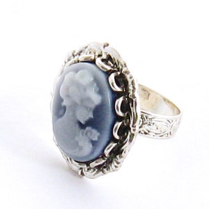 May include: A silver ring with a blue cameo featuring a woman's profile.