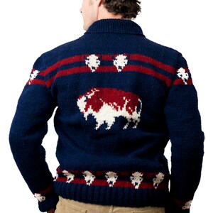 May include: A blue knitted sweater with a red and white buffalo design. The sweater has a collared neckline and long sleeves.