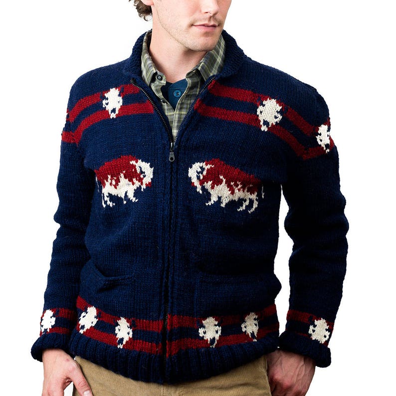 May include: A navy blue knitted cardigan with a zipper closure. The cardigan features a red and white striped pattern and a repeating design of white and red bison.