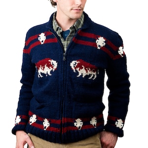 May include: A navy blue knitted cardigan with red and white stripes and a white buffalo design. The cardigan has a zipper closure and two pockets.