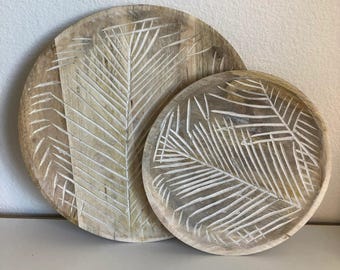 Plato de madera con detalles tallados en forma de hoja de palma.