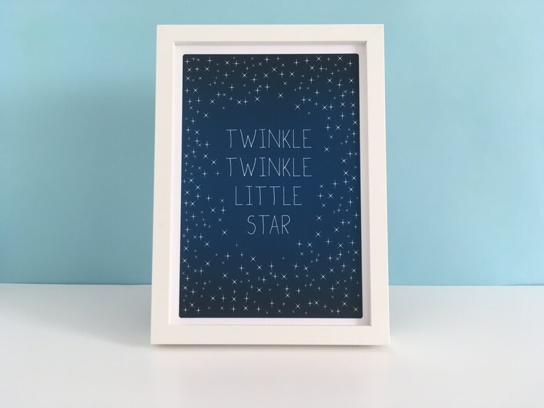 May include: A framed print with the words "Twinkle Twinkle Little Star" in white script on a dark blue background. The background is filled with small white star illustrations. The frame is white.