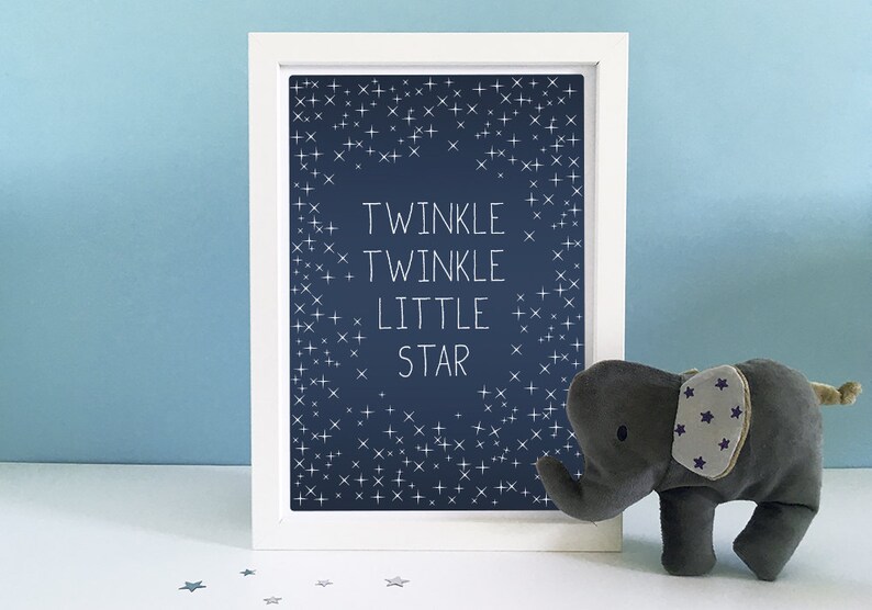 May include: A framed print with the words "Twinkle Twinkle Little Star" on a navy blue background with white star accents. A gray elephant plush toy with star-patterned ears sits beside the frame.
