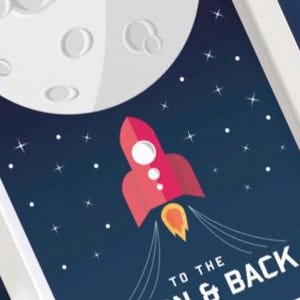 May include: A framed print showing a red rocket ship ascending towards a white moon against a dark blue starry sky. The text "TO THE MOON & BACK" is at the bottom.