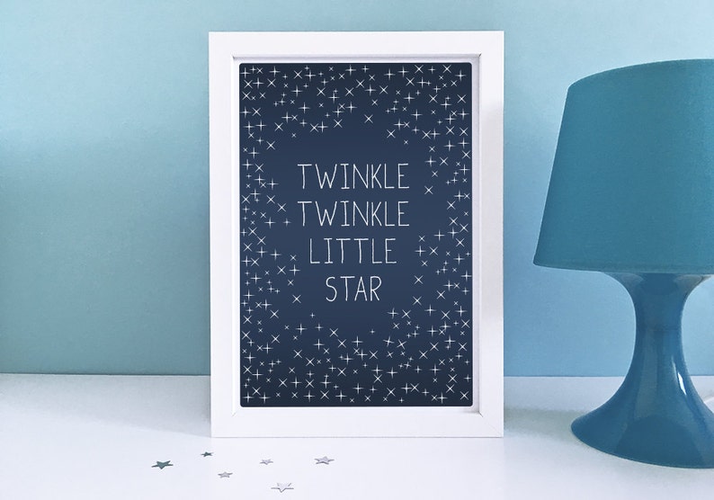 May include: A framed print with the words "Twinkle Twinkle Little Star" in white on a dark blue background, surrounded by white star shapes. A blue lamp is to the right.