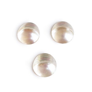 May include: Three white mother of pearl buttons.