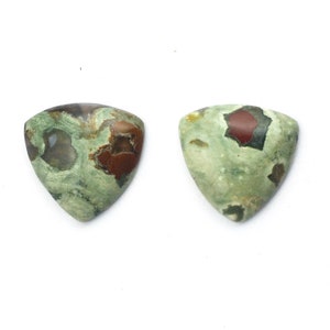 May include: Two triangular green, brown, and red jasper cabochons. The cabochons have a mottled pattern with a variety of colors and shapes.