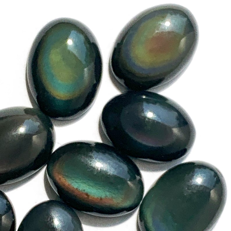 May include: A collection of oval-shaped obsidian stones with iridescent rainbow colors. The stones are smooth and polished, with a dark green base color.