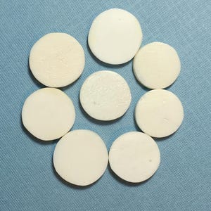 以下が含まれることがあります： 青い背景に円形に並んだ白い円盤8枚