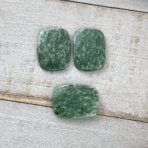 May include: Three polished, rectangular green stones with rounded corners. Each stone features a mottled, textured surface with varying shades of deep forest green and lighter sage green patterns throughout the smooth, flat, and polished stone faces.
