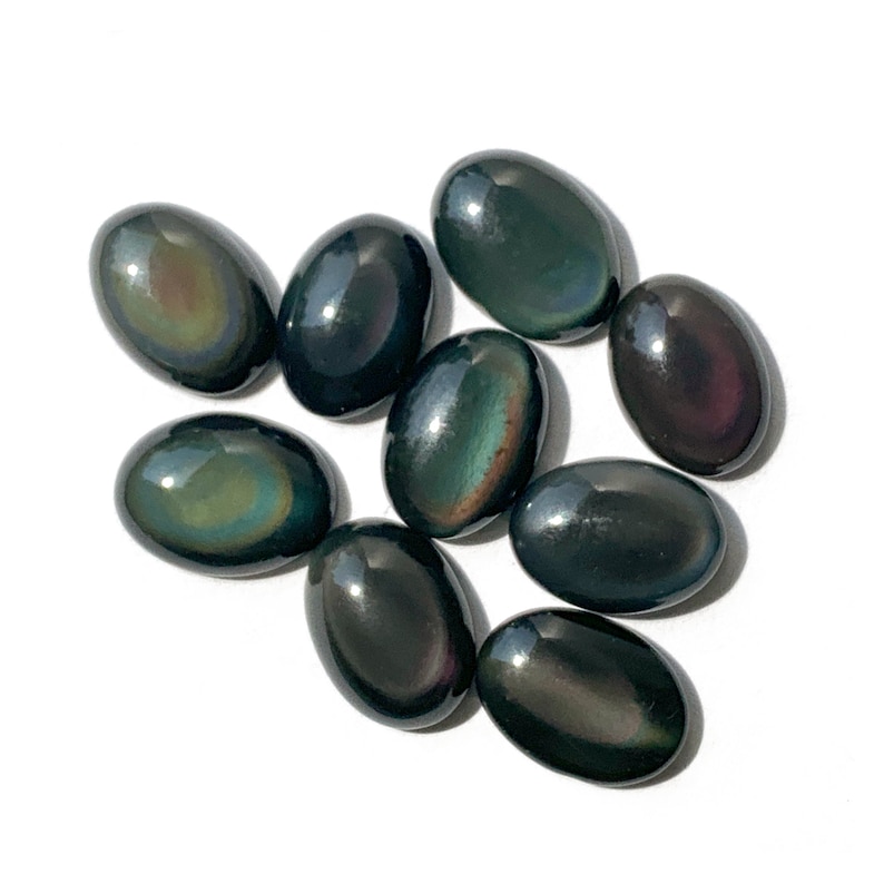May include: A collection of ten oval-shaped obsidian stones with iridescent rainbow colors. The stones are smooth and polished.