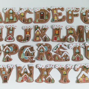 May include: A complete alphabet of gingerbread house letters, each with white icing and decorative features. The letters are brown with white icing and candy cane trim, creating a festive and whimsical design.