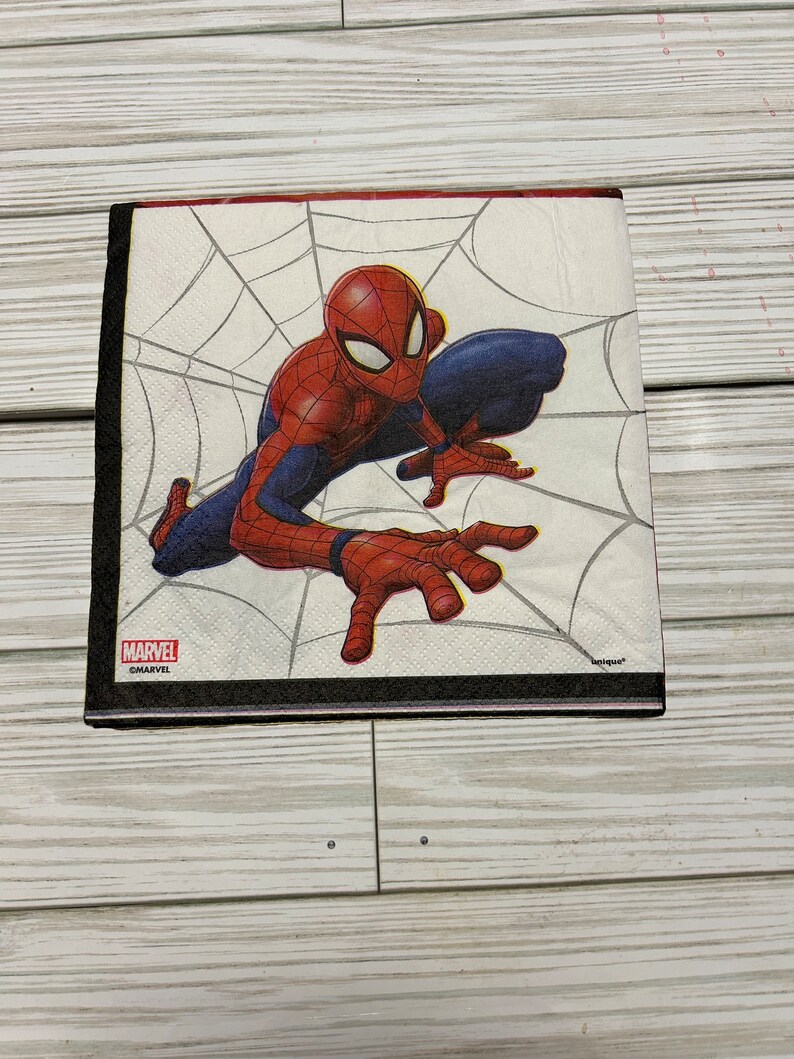 Puede incluir: Una servilleta de papel blanca con un personaje de Spiderman rojo y azul arrastr&aacute;ndose por una telara&ntilde;a. La servilleta tiene las palabras "MARVEL" y "&copy;MARVEL" impresas en ella.