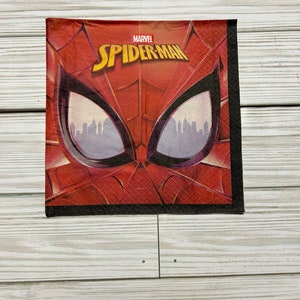 Puede incluir: Servilleta de papel roja y negra con una imagen de primer plano de la cara de Spider-Man. El texto "MARVEL SPIDER-MAN" est&aacute; impreso en la servilleta.