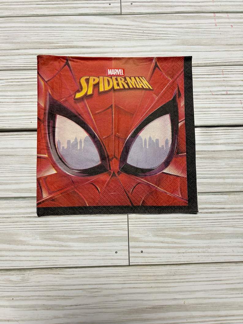 Puede incluir: Servilleta de papel roja y negra con una imagen de primer plano de la cara de Spider-Man. El texto "MARVEL SPIDER-MAN" est&aacute; impreso en la servilleta.