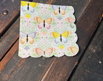 Servilleta de papel para cóctel con mariposas en tonos pastel. Solo un lado tiene el estampado dorado.