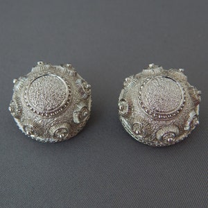 Pendientes MONET de clip, redondos, plateados, con diseño de escudo egipcio antiguo.