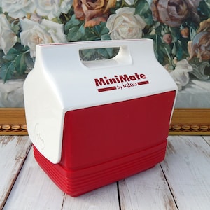 May include: White and red MiniMate cooler by Igloo. The cooler has a white top with the brand name and a red bottom with a textured design.