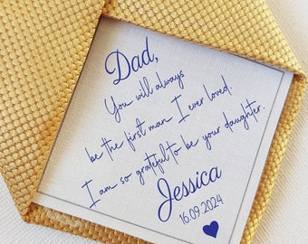 May include: A gold tie with a white card attached to it. The card has a handwritten message that reads "Dad, You will always be the first man I ever loved. I am so grateful to be your daughter. Jessica 16.09.2024".