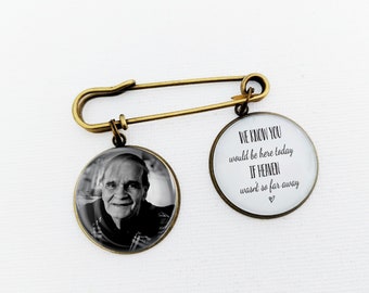 Può includere: Una spilla da balia color bronzo con due ciondoli circolari. Un ciondolo mostra un ritratto in bianco e nero di un uomo anziano, mentre l'altro presenta il testo nero: WE KNOW YOU would be here today If HEAVEN wasn't so far away.