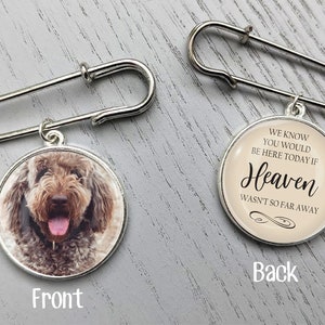 May include: A silver safety pin with a round charm attached. The front of the charm features a photo of a brown and white dog. The back of the charm has the text "WE KNOW YOU WOULD BE HERE TODAY IF Heaven WASN'T SO FAR AWAY".