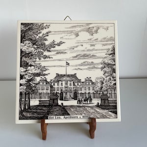 May include: A black and white illustration of a palace with a large tree in the foreground. The text "Het Loo, Apeldoorn + 1850" is printed below the image.