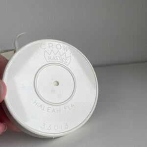 May include: White plastic lid with the text "CROWN PLASTICS" and "HIALEAH FLA 33013" printed on it.