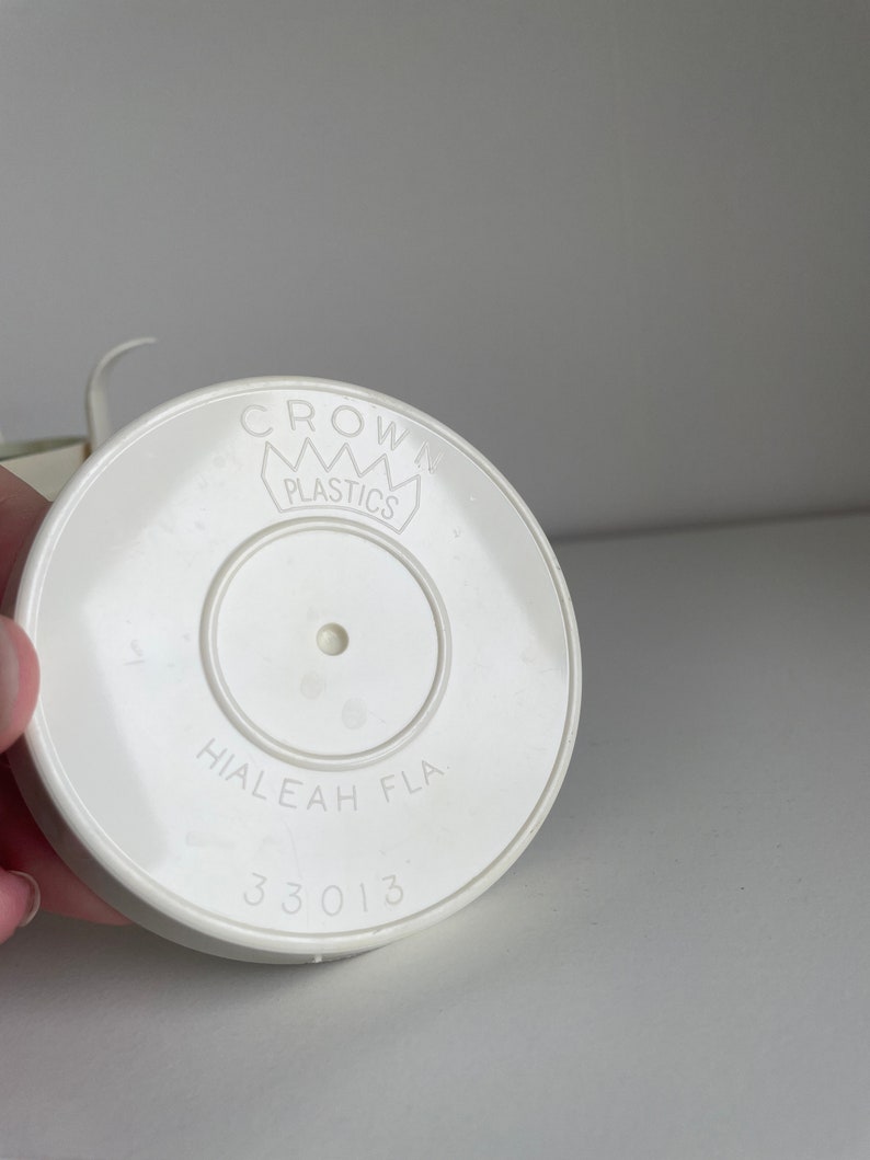 May include: White plastic lid with the text "CROWN PLASTICS" and "HIALEAH FLA 33013" printed on it.