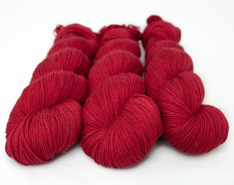 May include: Three skeins of deep red yarn, wound into balls.