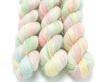 May include: Three skeins of yarn in a pastel colorway with shades of pink, green, blue, and yellow.