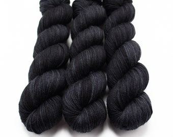 May include: Three skeins of black yarn with a subtle dark grey marled effect.