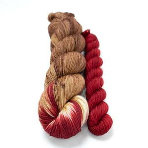May include: Two skeins of yarn, one brown with white and cream speckles, and one red.