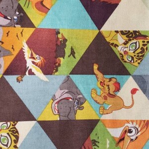 May include: Fabric with a repeating geometric pattern of triangles. Each triangle features a different cartoon animal, including a lion, elephant, and bird, in a variety of colors such as blue, brown, and yellow.