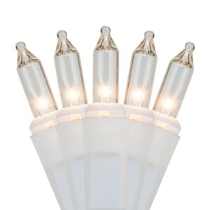 May include: Close-up of a string of clear mini lights with a white base. The bulbs are lit, emitting a warm, soft glow. The lights are designed for decorative purposes, suitable for holiday or event decor.