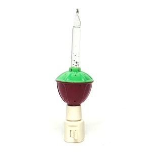 May include: A red and green night light with a clear glass bulb and a white switch. The bulb has glitter inside.