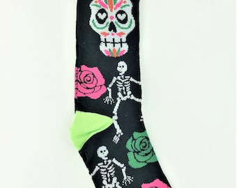 May include: Black crew socks with a green, pink, and white sugar skull design, green roses, and skeletons. The socks have a green cuff and the tag says "crew socks".