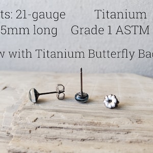 May include: Three titanium earring posts with butterfly backs. The posts are 21 gauge and 11.5mm long. The text "Titanium Grade 1 ASTM F67" and "Now with Titanium Butterfly Backs!" is visible in the image.